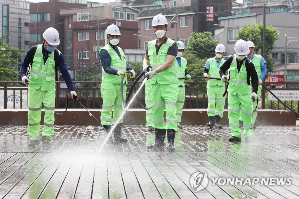 Sanitation workers disinfect streets in northern Seoul on Jan. 4, 2020, to prevent the spread of the new coronavirus. (Yonhap)