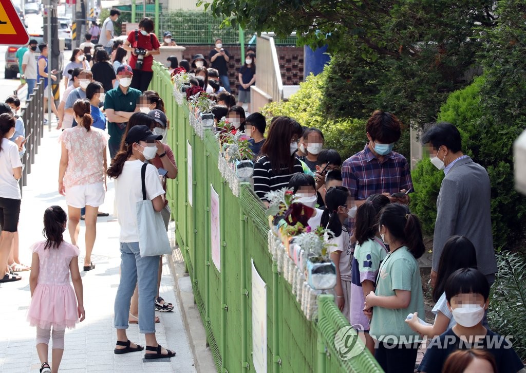 Students at Seoul's Mukhyeon Elementary School in Jungnang Ward line up to get tested for the coronavirus on July 5, 2020, a day after one of the students at the school tested positive for COVID-19. (Yonhap)