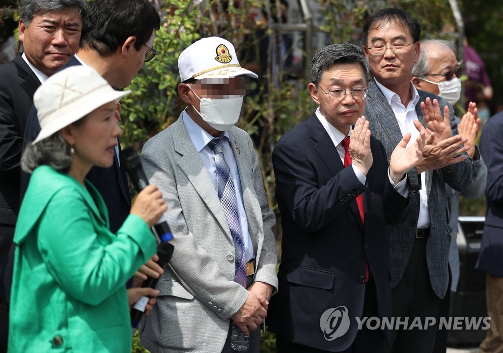 A former prisoner of war surnamed Han (C) and his legal representatives pose for photos on July 7, 2020, after winning a damage suit in Seoul against North Korea and its leader Kim Jong-un for being forced into labor in the North. (Yonhap)