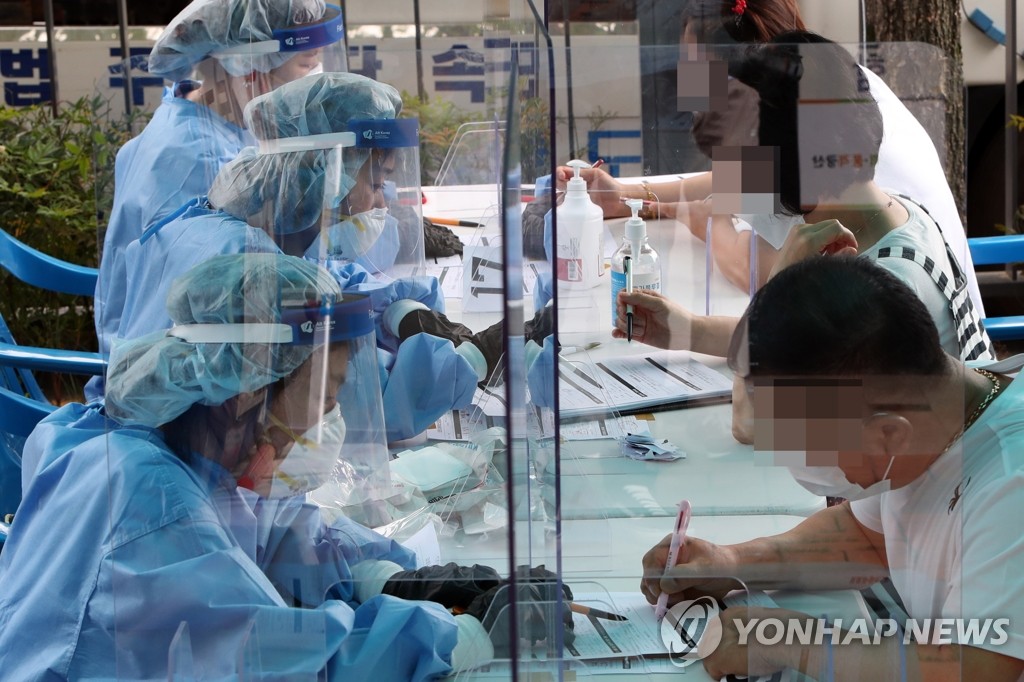 Visitors sign documents at a makeshift clinic in Gwangju, 330 kilometers southwest of Seoul, on July 7, 2020. (Yonhap)