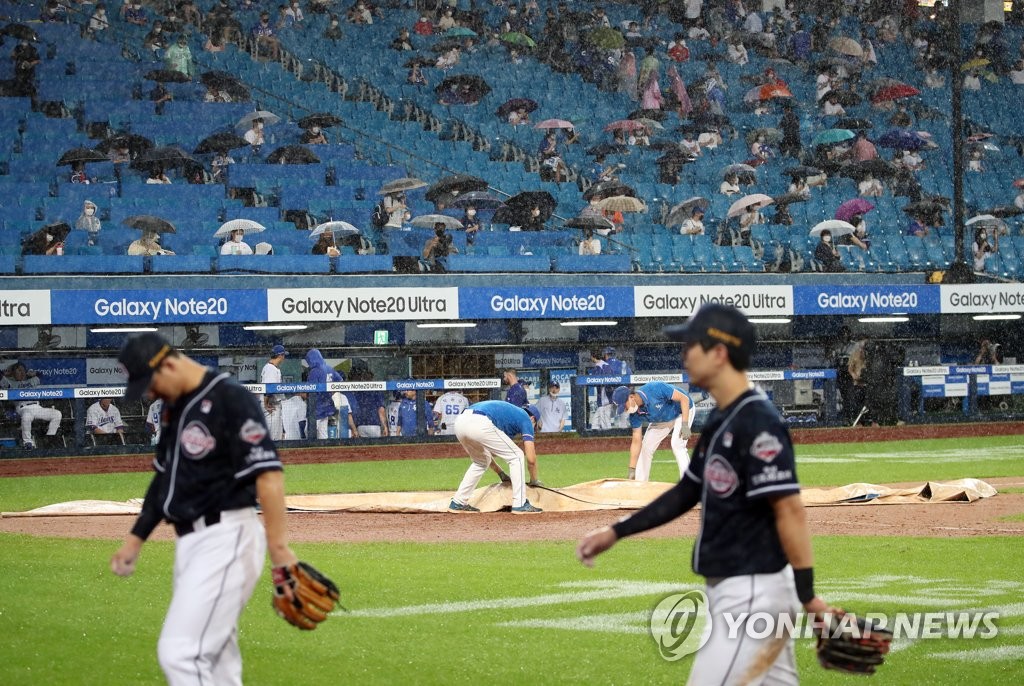 Doosan Bears players walk off the field at Daegu Samsung Lions Park in Daegu, 300 kilometers southeast of Seoul, during a rain delay in a Korea Baseball Organization regular season game against the Samsung Lions on Aug. 11, 2020. (Yonhap)