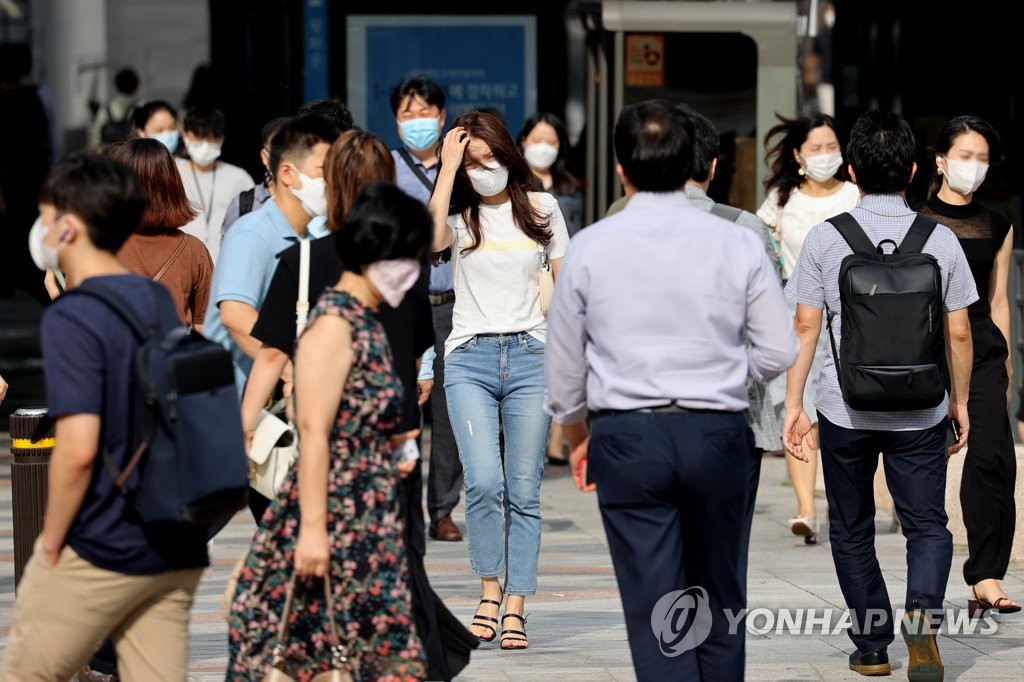 People wearing masks report to work at Gwanghwamun Square in Seoul on Aug. 19, 2020, as the coronavirus rages again in the country, especially in the Seoul metropolitan area. (Yonhap)