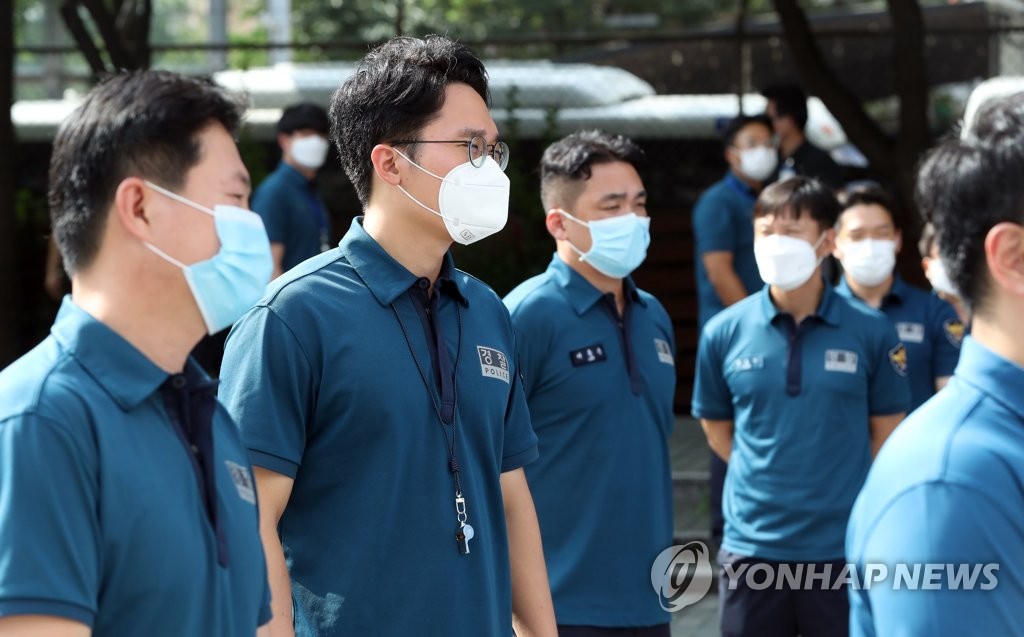 Police officers wait to receive new coronavirus tests at a makeshift clinic in Seoul on Aug. 19, 2020. (Yonhap)