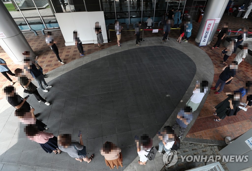 Citizens wait to receive new coronavirus tests at a screening center in Wonju, 132 kilometers east of Seoul, on Aug. 21, 2020. (Yonhap)