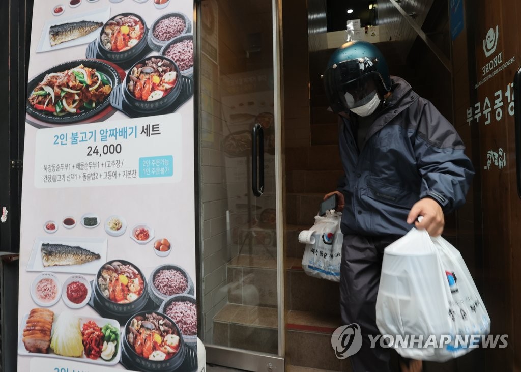 A delivery man takes out meals from a restaurant in central Seoul on Sept. 2, 2020. (Yonhap)