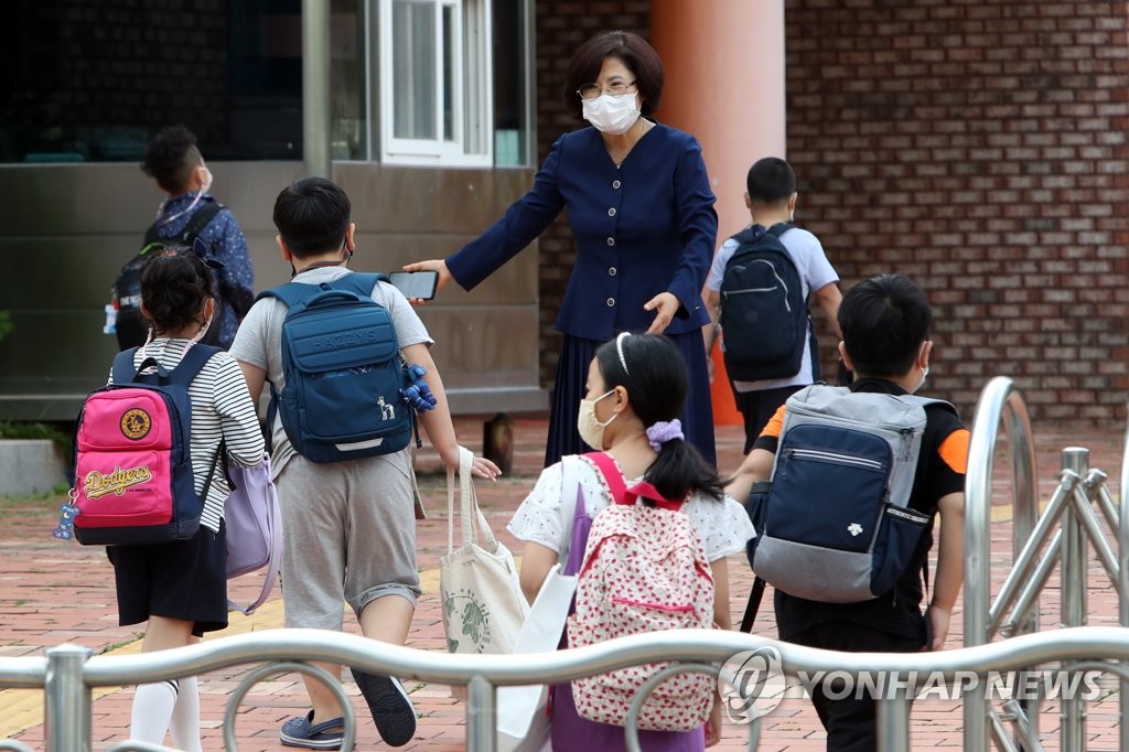 한 초등학교에서 교장 선생님이 학생을 맞이하고 있다. [연합뉴스 자료사진]