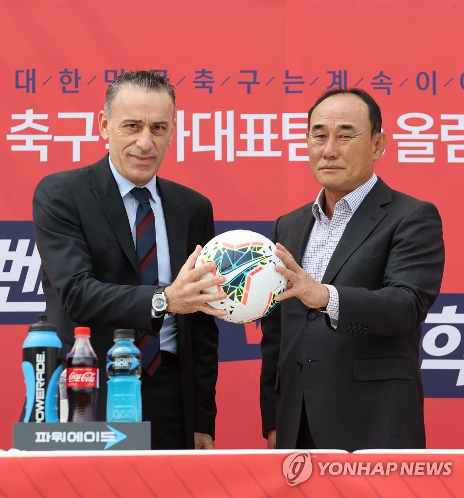 Paulo Bento (L), head coach of the South Korean men's senior national football team, and Kim Hak-bum, who coaches the men's under-23 national football team, pose for photos ahead of a press conference for their exhibition matches at Goyang Stadium in Goyang, Gyeonggi Province, on Sept. 28, 2020. (Yonhap)