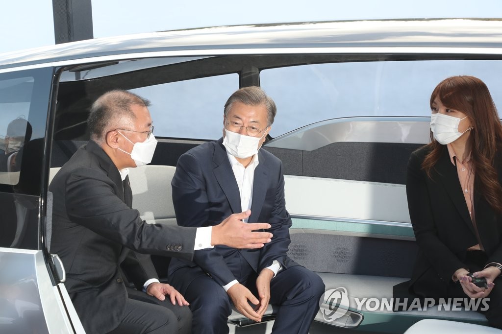Hyundai Group Chairman Chung Euisun (L) shares his company's next-generation car vision with South Korean President Moon Jae-in (C) aboard a self-driving concept car at Hyundai's factory in Ulsan, 414 kilometers southeast of Seoul, on Oct. 30, 2020. (Yonhap)