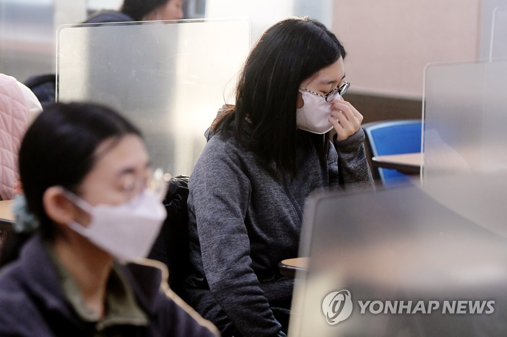 2021년도 대학수학능력시험일인 지난해 12월 3일 오전 서울의 한 고등학교에서 시험실에 입실한 수험생이 마스크를 고쳐 쓰고 있다. [사진공동취재단. 연합뉴스 자료사진. 재판매 및 DB 금지]