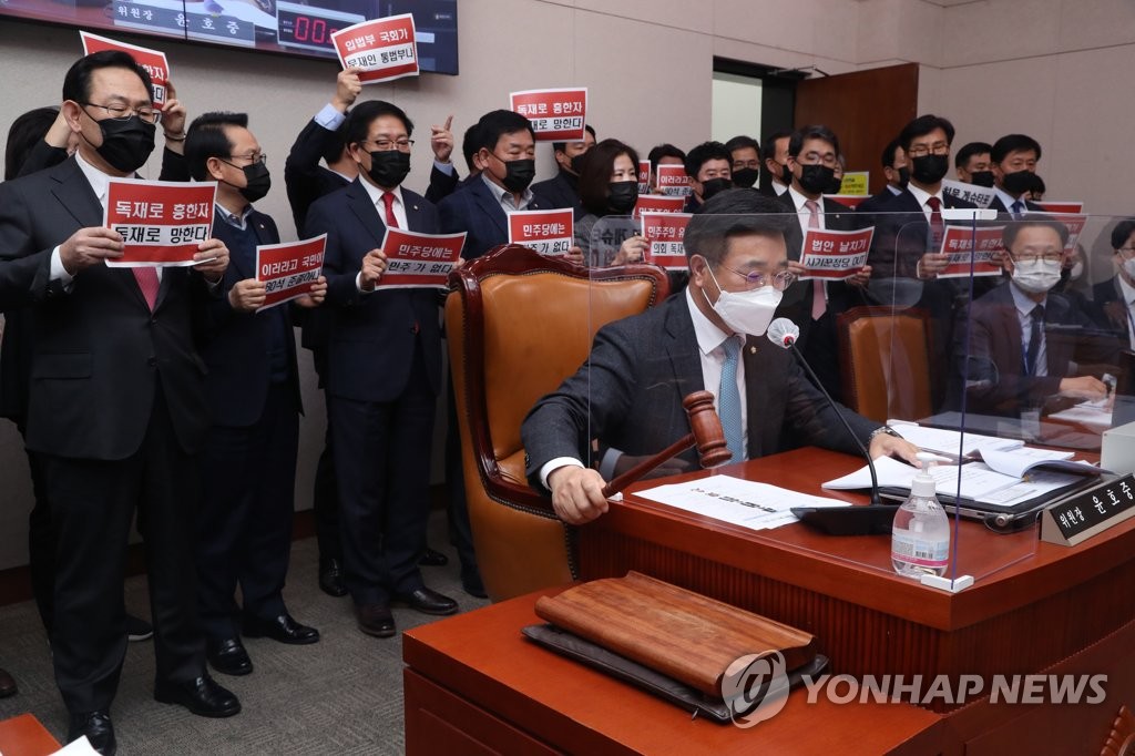 People Power Party lawmakers on the Legislation and Judiciary Committee encircle committee chairman Rep. Yun Ho-jung as he is about to pass a bill on revising a commercial law at the National Assembly in Seoul on Dec. 8, 2020. (Yonhap)
