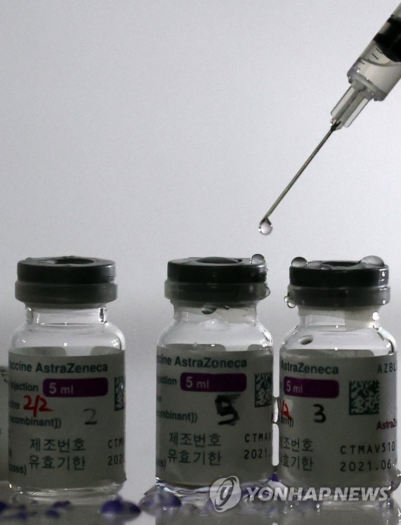 This photo, taken on Feb. 16, 2021, shows bottles of AstraZeneca's COVID-19 vaccine and a syringe, as medical workers are trained on how to give coronavirus vaccine shots at a training facility of the Korean Nurses Association in Seoul. (Yonhap)