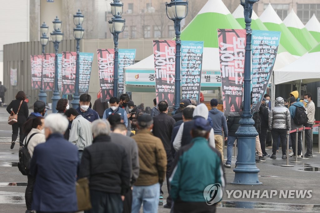 ソウル駅前の臨時検査所で、検査の順番を待つ市民が長い列をつくっている＝２９日、ソウル（聯合ニュース）