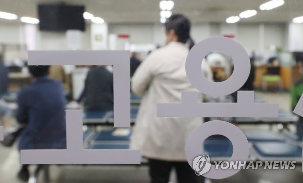 Des citoyens attendent de déposer une demande de chômage dans un centre d'emploi d'Etat situé dans le nord de Séoul, le 12 avril 2021.