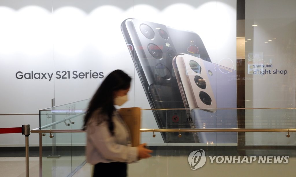 A person walks by an advertisement board for Samsung Electronics Co.'s Galaxy S21 series smartphones on April 29, 2021, at the company's building in southern Seoul. (Yonhap)