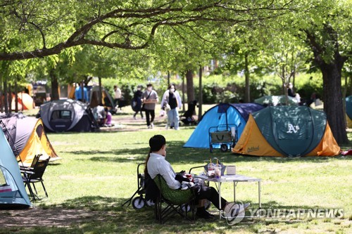 日曜日の午後、ソウル市内の公園でくつろぐ市民＝９日、ソウル（聯合ニュース）