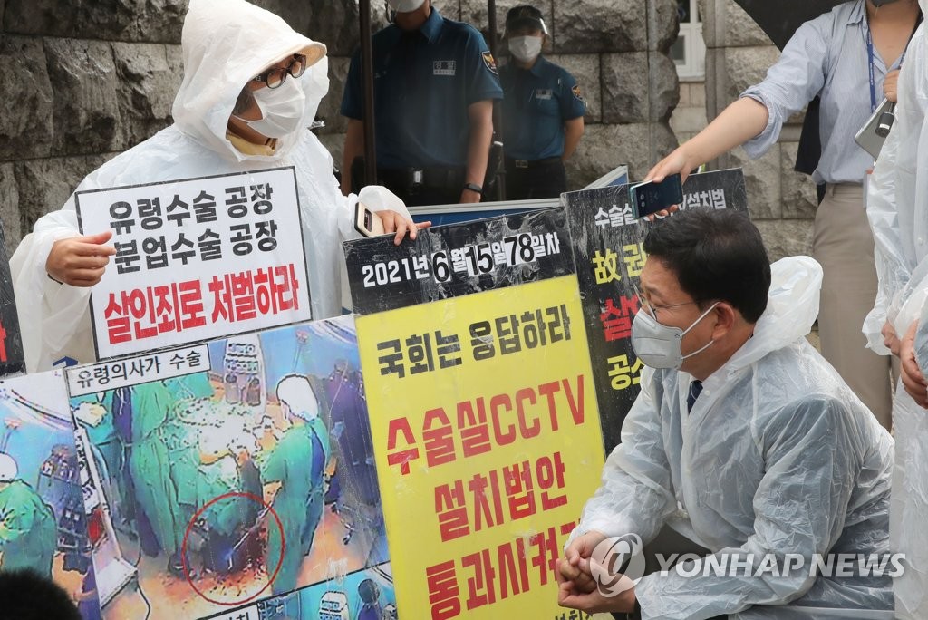 Lee Na-geum (L), who lost her son in a botched plastic surgery in 2016, holds a protest outside the National Assembly in Seoul on June 15, 2021, to demand passage of a bill mandating surveillance cameras in hospital operating rooms. (Yonhap)