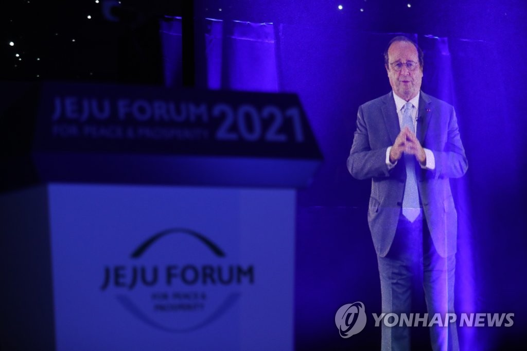Une image holographique montre l'ancien président français François Hollande s'exprimant au 16e Forum de Jeju pour la paix et la prospérité dans un hôtel de l'île de Jeju, le 25 juin 2021.