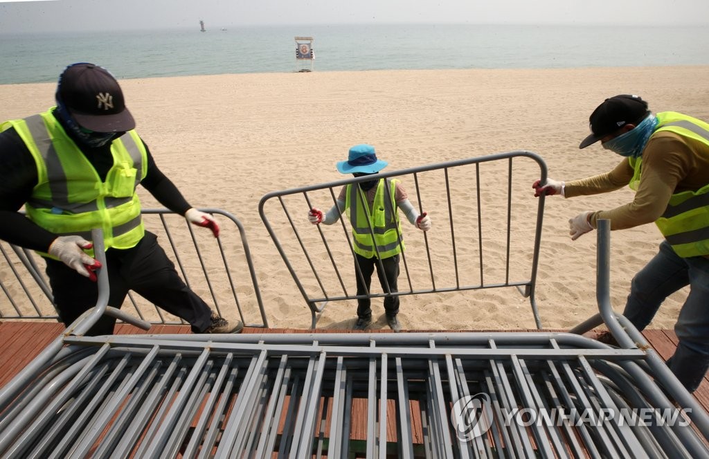 Officials set up a metal fence at a beach in Gangneung, 237 kilometers east of Seoul, on July 13, 2021. (Yonhap)