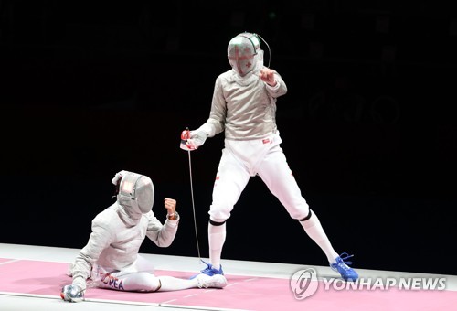 Kim Jung-hwan of South Korea (R) celebrates a point against Sandro Bazadze of Georgia during the bronze medal match of the men's individual sabre event at the Tokyo Olympics at Makuhari Messe Hall B in Chiba, Japan, on July 24, 2021. (Yonhap)