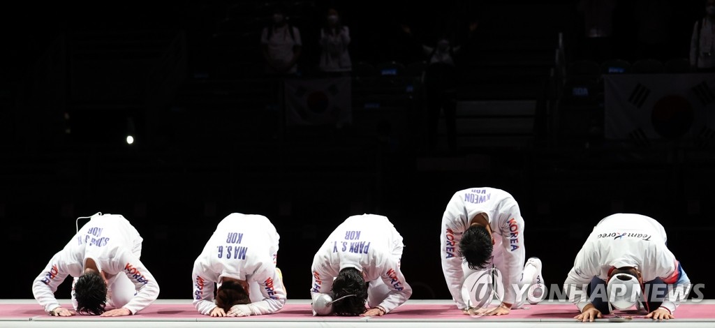 Members of the South Korean men's epee fencing team take a traditional Korean bow after winning the bronze medal in men's epee team fencing at the Tokyo Olympics at Makuhari Messe Hall B in Chiba, Japan, on July 30, 2021. (Yonhap)