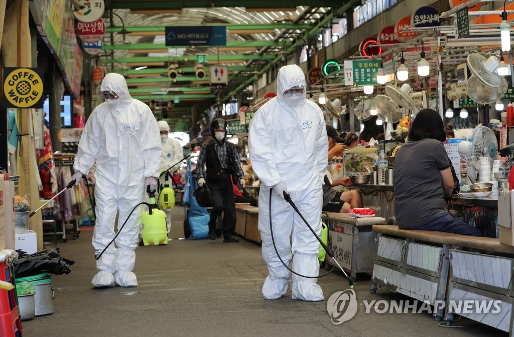 Health workers in protective gear disinfect a traditional market in Seoul on Sept. 16, 2021. (Yonhap)