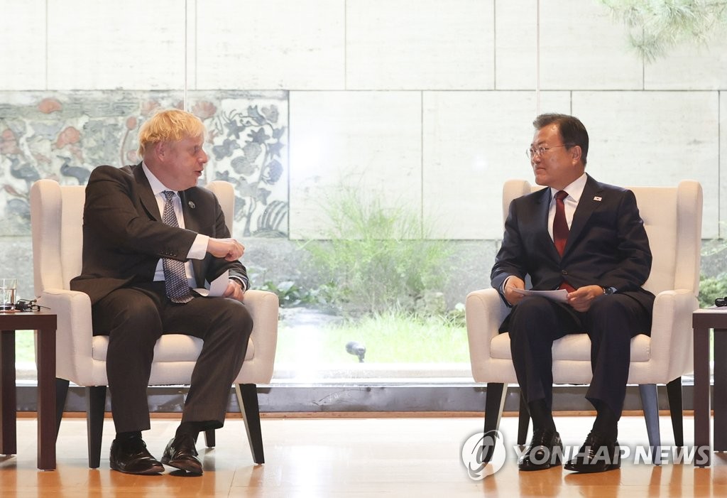 El presidente surcoreano, Moon Jae-in (dcha.), y el primer ministro del Reino Unido, Boris Johnson, conversan durante sus diálogos cumbre, el 20 de septiembre de 2021 (hora local), en Nueva York, al margen de la 76ª Asamblea General de la ONU.
