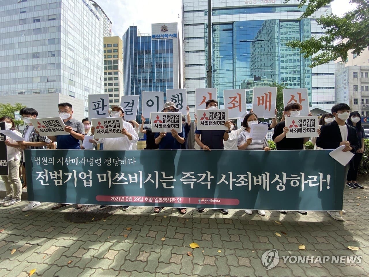 Un groupe de militants civiques sud-coréens appelle la société japonaise Mitsubishi Heavy Industries Ltd. à présenter des excuses et à dédommager les victimes coréennes de son travail forcé en temps de guerre devant le consulat général du Japon à Busan, le 29 septembre 2021.