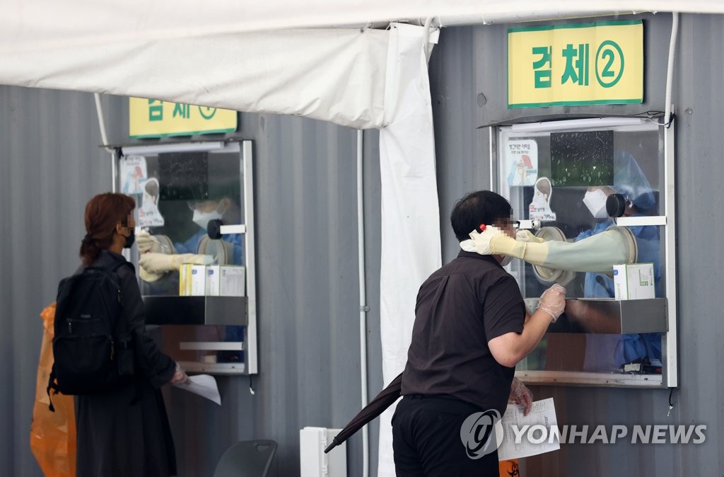People receive COVID-19 tests at a makeshift clinic in central Seoul on Oct. 9, 2021. (Yonhap)