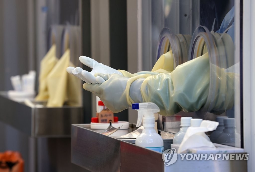 A medical worker's hands are seen at a COVID-19 testing booth set up at a park in Yeouido, eastern Seoul, on Oct. 29, 2021. (Yonhap)