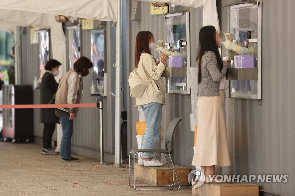 Health workers take nasal swab samples from people at a makeshift COVID-19 testing facility in Seoul on Nov. 6, 2021. (Yonhap)