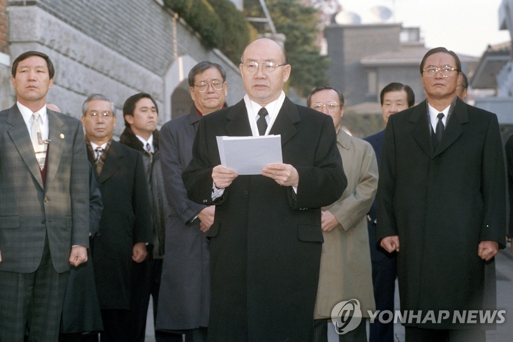 This file photo shows former President Chun Doo-hwan (C) reading a statement refusing to cooperate with the prosecution's investigation into his alleged misdeeds outside his home in western Seoul on Dec. 2, 1995. (Yonhap)