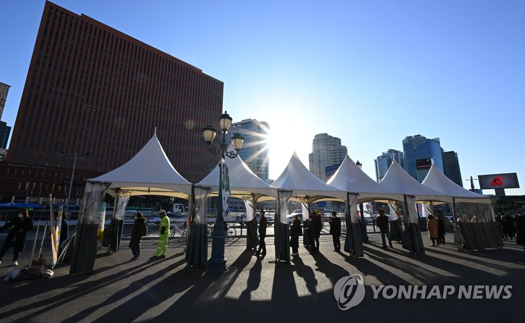 People wait in line to get COVID-19 tests at a virus testing site near Seoul Station in central Seoul on Nov. 26, 2021. (Yonhap)