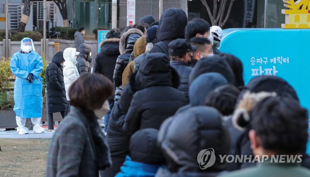 This Dec. 1, 2021, file photo shows people lined up in front of a COVID-19 testing center in southern Seoul. (Yonhap)