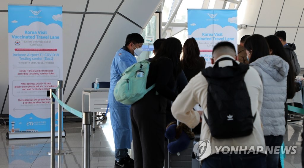 Des voyageurs attendent de subir un test de dépistage du nouveau coronavirus (Covid-19) dans un centre installé à l'aéroport international d'Incheon, le mercredi 1er décembre 2021.