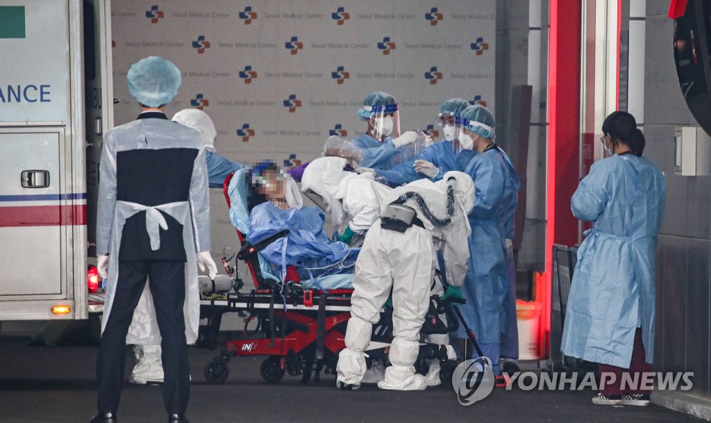 A COVID-19 patient is being transported on a stretcher from an ambulance at Seoul Medical Center in Seoul on Dec. 15, 2021. (Yonhap) 