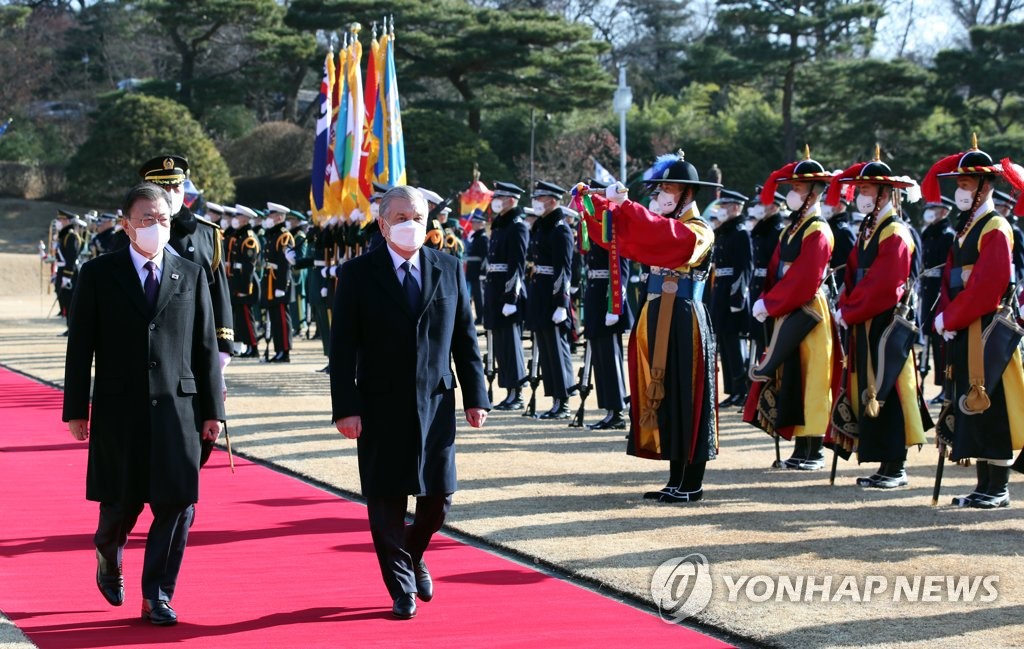 Uzbek President Shavkat Mirziyoyev (R), accompanied by South Korean President Moon Jae-in, inspects an honor guard during a welcome ceremony for the Central Asian country's leader at the presidential office Cheong Wa Dae in Seoul on Dec. 17, 2021. (Yonhap)