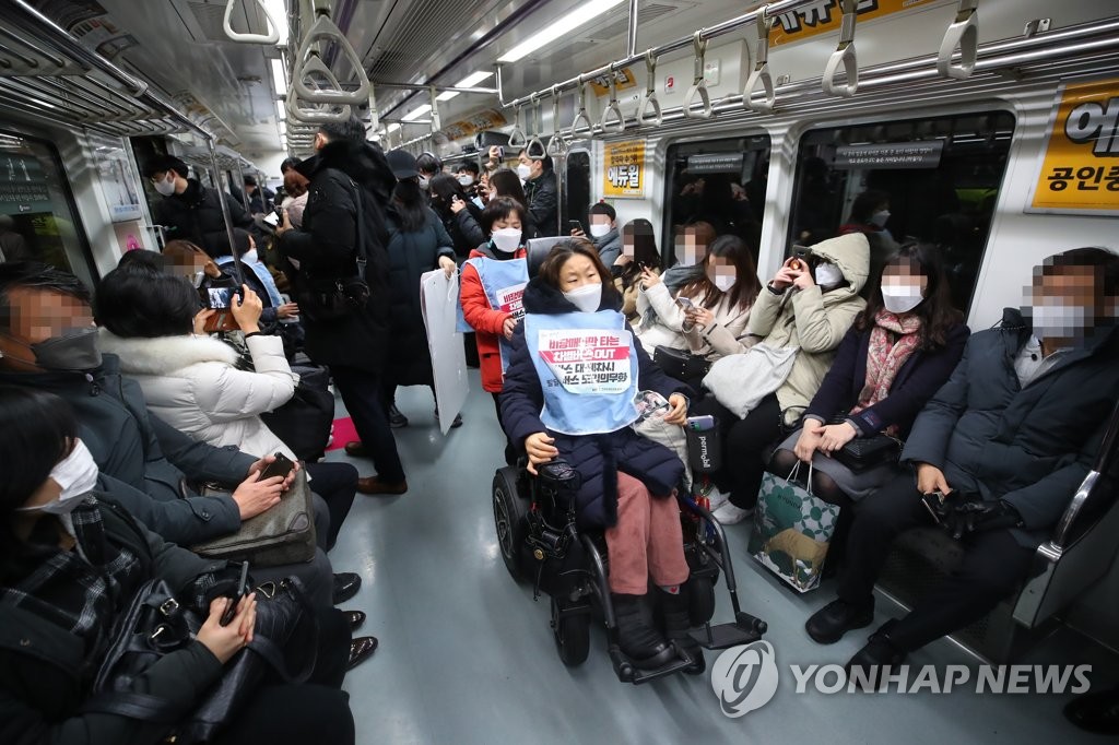 This file photo shows members of Solidarity Against Disability Discrimination staging a subway protest calling for improvement of mobility rights on a train at Gwanghwamun Station in central Seoul on Dec. 20, 2021. (Yonhap)