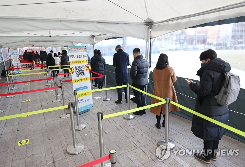 People line up to get tested for COVID-19 at a makeshift clinic in Seoul on Dec. 30, 2021. (Yonhap)