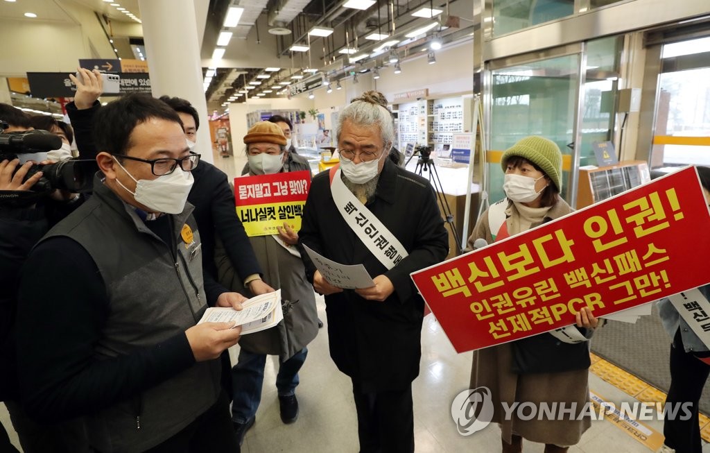 A civic group against the vaccine pass expansion to large shopping facilities holds a protest at an E-Mart outlet in Cheongju, 140 kilometers south of Seoul, on Jan. 10, 2021. (Yonhap)