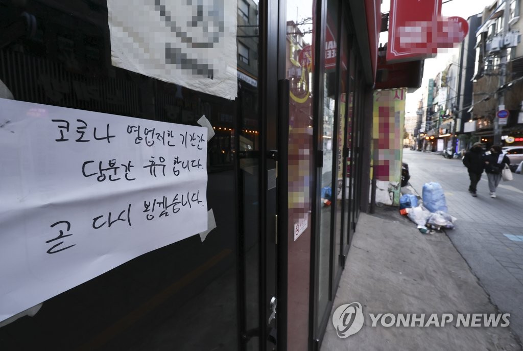 This photo, taken Jan. 16, 2022, shows a sign put up at a restaurant in the university district of Shinchon in western Seoul that says it will temporary close due to the COVID-19 pandemic. (Yonhap)