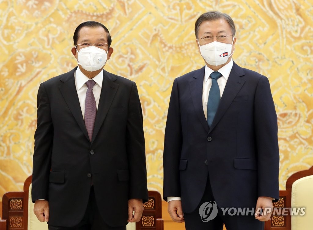 El presidente de Corea del Sur, Moon Jae-in (dcha.), posa ante la cámara junto al primer ministro de Camboya, Hun Sen, el 11 de febrero de 2022, en la oficina presidencial de Seúl, Cheong Wa Dae.