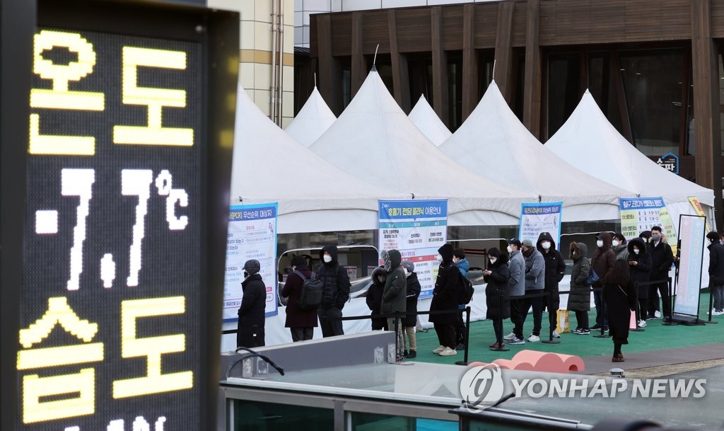 People wait in line to receive tests amid a cold snap at a COVID-19 testing station in Seoul on Feb. 16, 2022, when the country reported 90,443 new cases. (Yonhap)