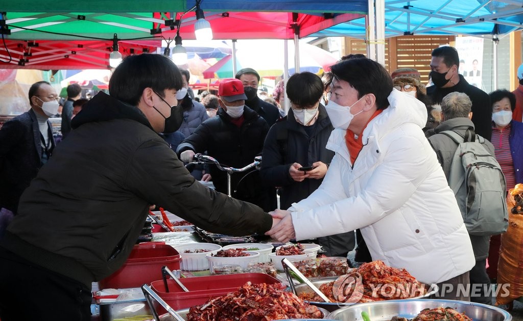 Ahn Cheol-soo (R), the presidential candidate of the minor opposition People's Party, meets with a shop owner during a campaign stop at a traditional market in Gochang, North Jeolla Province, southwestern South Korea, on Feb. 28, 2022, ahead of the March 9 presidential election. (Pool photo) (Yonhap)