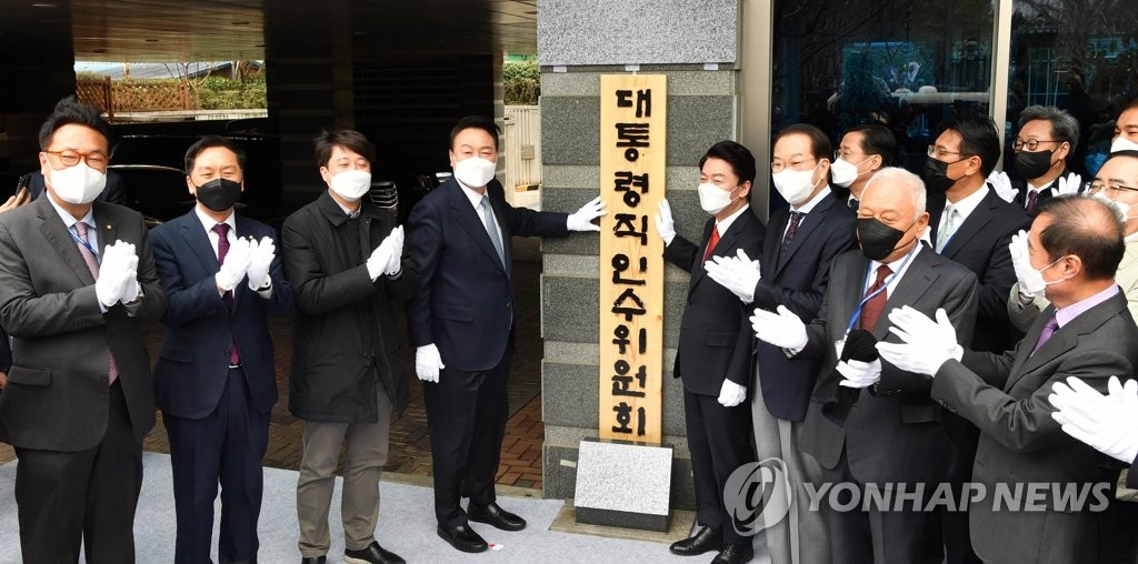 President-elect Yoon Suk-yeol (4th from L), Ahn Cheol-soo (5th from L), chief of the presidential transition committee, and other participants applaud during a ceremony to unveil a plaque displaying the committee's Korean name at its office in Seoul on March 18, 2022. (Pool photo) (Yonhap)