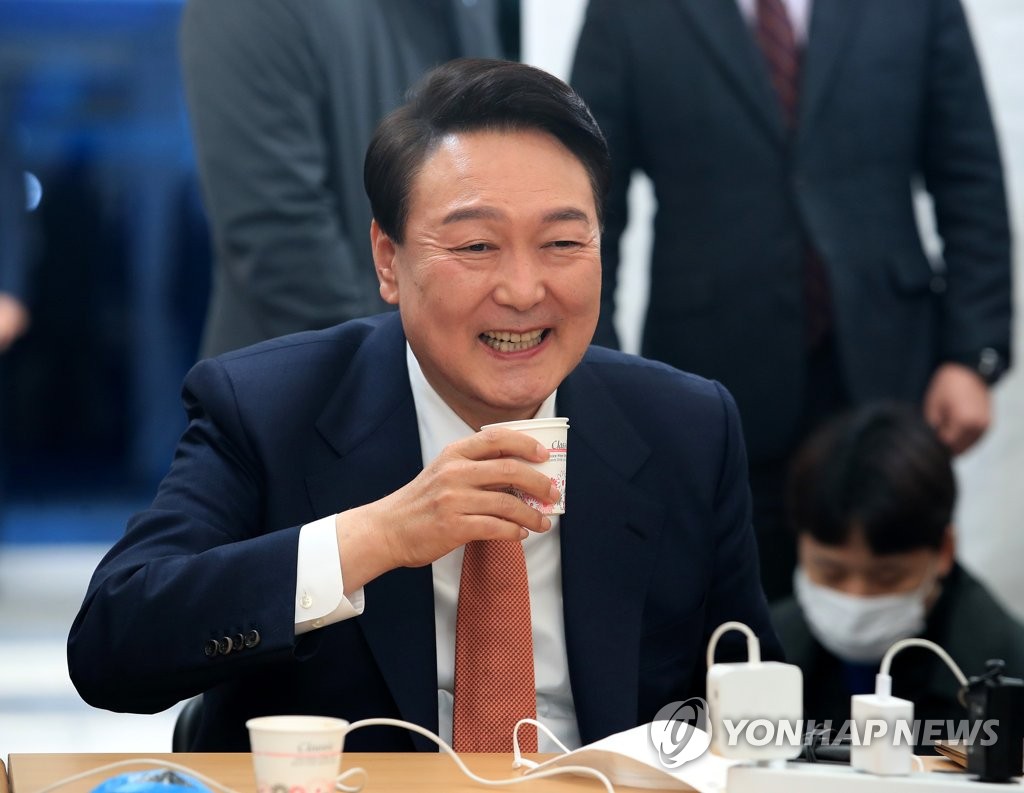 President-elect Yoon Suk-yeol laughs while speaking to reporters inside a makeshift press room set up outside his office in Seoul on March 24, 2022. (Pool photo) (Yonhap)