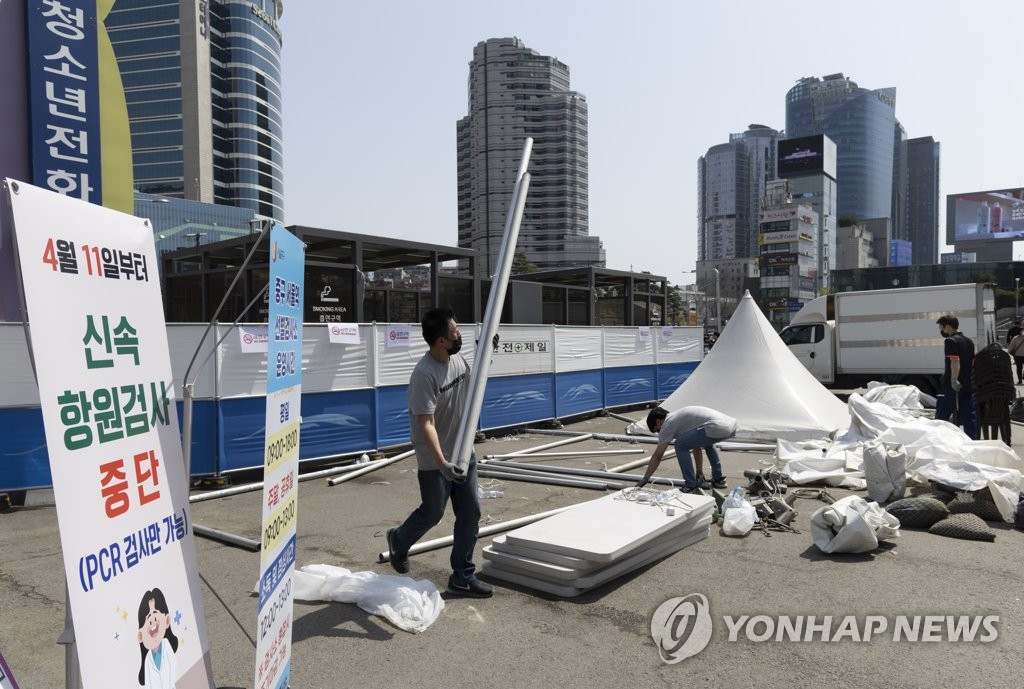 Some COVID-19 testing tents at Seoul Station are being disassembled on April 10, 2022, as all makeshift COVID-19 testing booths will stop carrying out free rapid antigen tests and only provide polymerase chain reaction tests for potential patients in high-risk groups starting April 11. (Yonhap) 