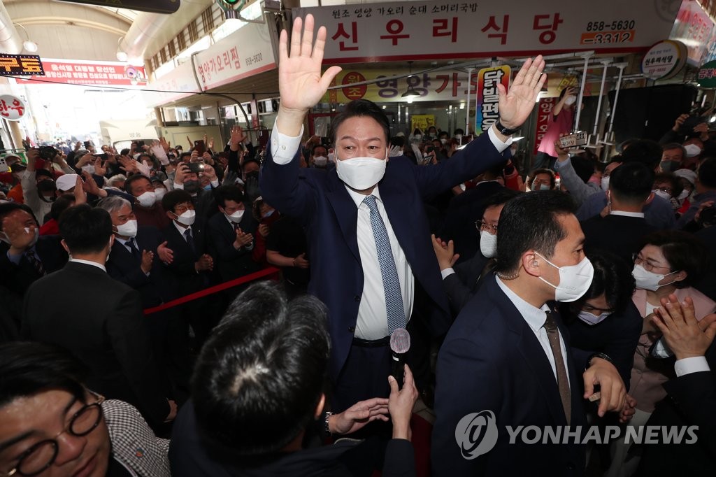 El presidente electo, Yoon Suk-yeol (centro), saluda a la gente, el 11 de abril de 2022, durante su visita a un mercado en Andong, provincia de Gyeongsang del Norte, en el sureste de Corea del Sur.