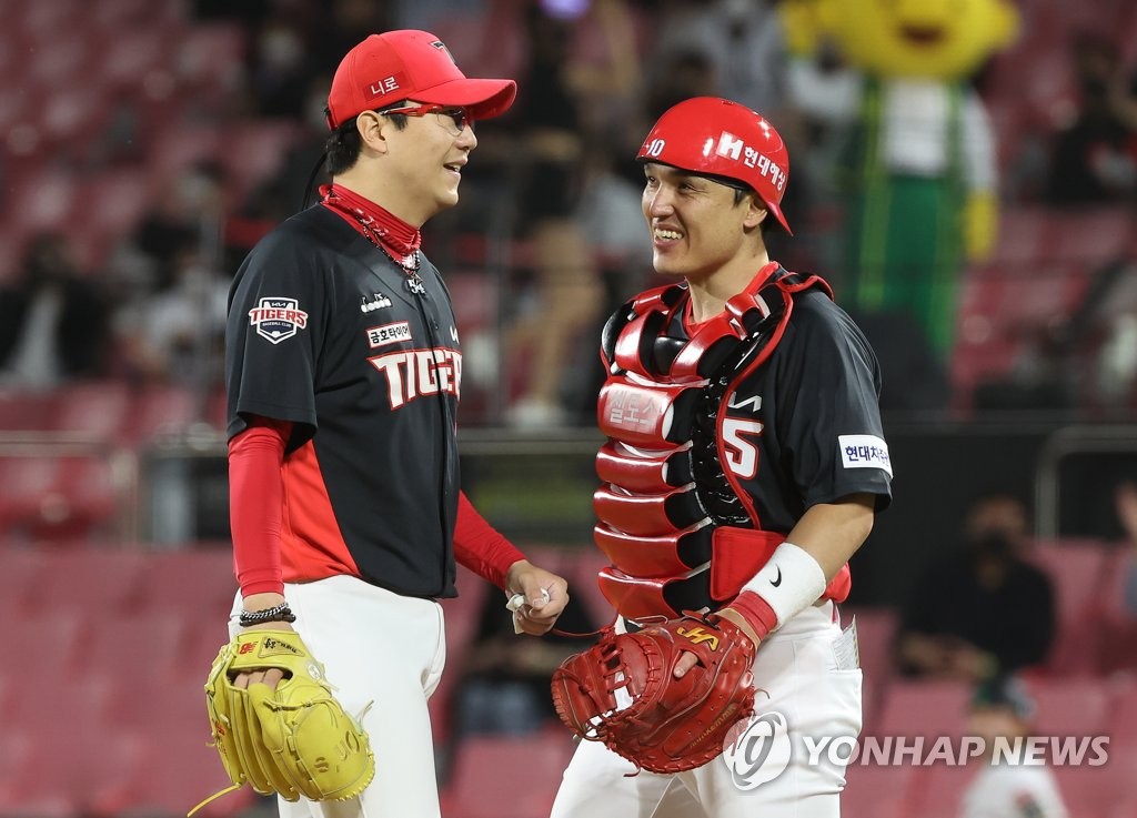 Yang Hyeon-jong of the Kia Tigers (L) shares a smile with his catcher Park Dong-won before leaving the mound during the bottom of the seventh inning of a Korea Baseball Organization regular season game against the KT Wiz at KT Wiz Park in Suwon, 45 kilometers south of Seoul, on April 26, 2022. (Yonhap)