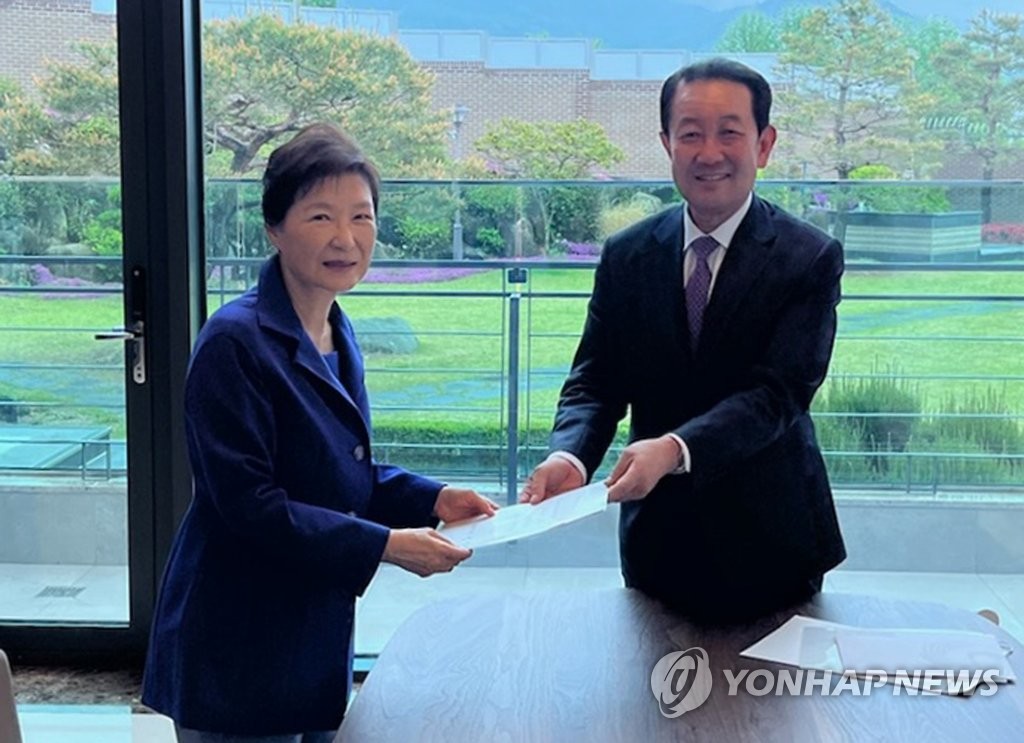 This photo provided by the presidential inauguration preparatory committee on April 27, 2022, shows the committee chief Park Joo-sun delivering President-elect Yoon Suk-yeol's letter and invitation to the May 10 inauguration ceremony to former President Park Geun-hye (L) at her home in Daegu on April 26, 2022. (PHOTO NOT FOR SALE) (Yonhap)