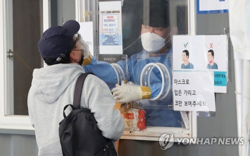Un trabajador sanitario realiza un examen de coronavirus a un ciudadano, el 5 de mayo de 2022, en una clínica provisional frente a la Estación de Seúl, en la capital surcoreana.